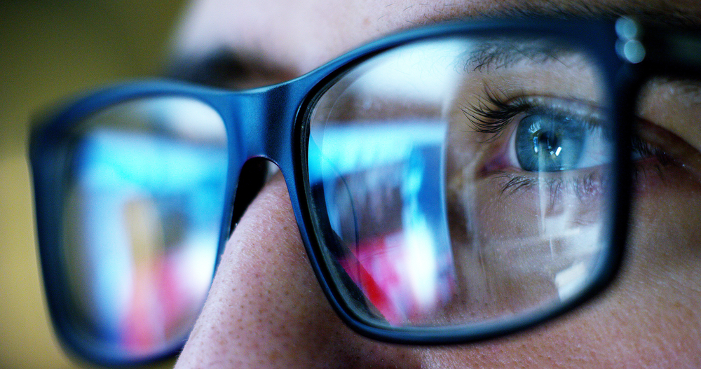 close-up of a person's eyes through black eyeglasses